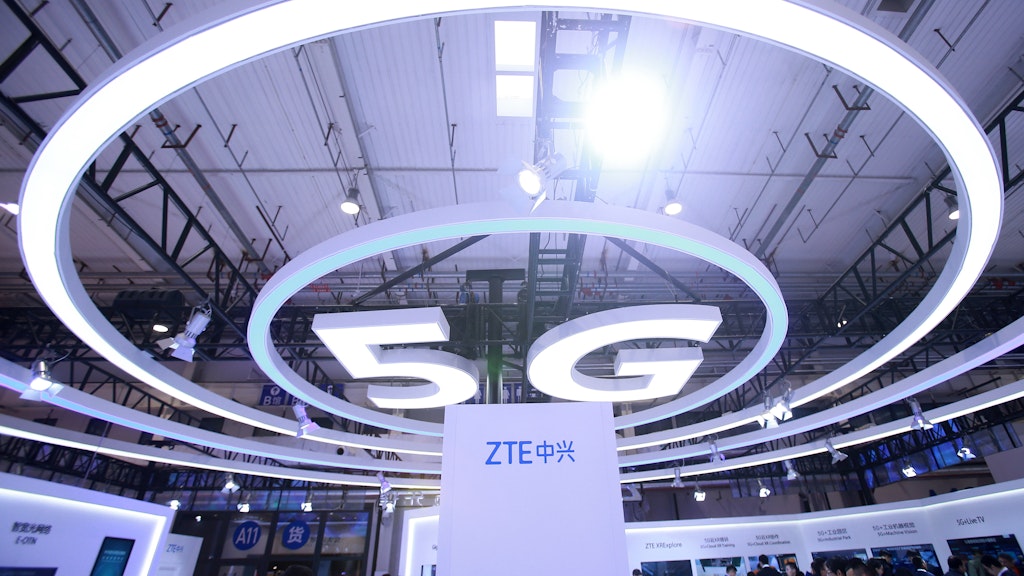 Ein 5G-Logo hängt an der Decke einer Messehalle. (Symbolbild)