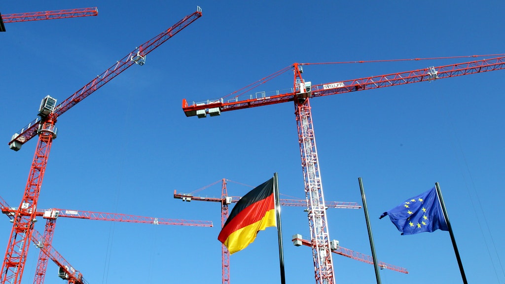 Die europäische und die deutsche Flagge ist im Regierungsviertel zwischen Baukränen zu sehen. Die deutsche Wirtschaft ist der befürchteten Rezession entkommen.