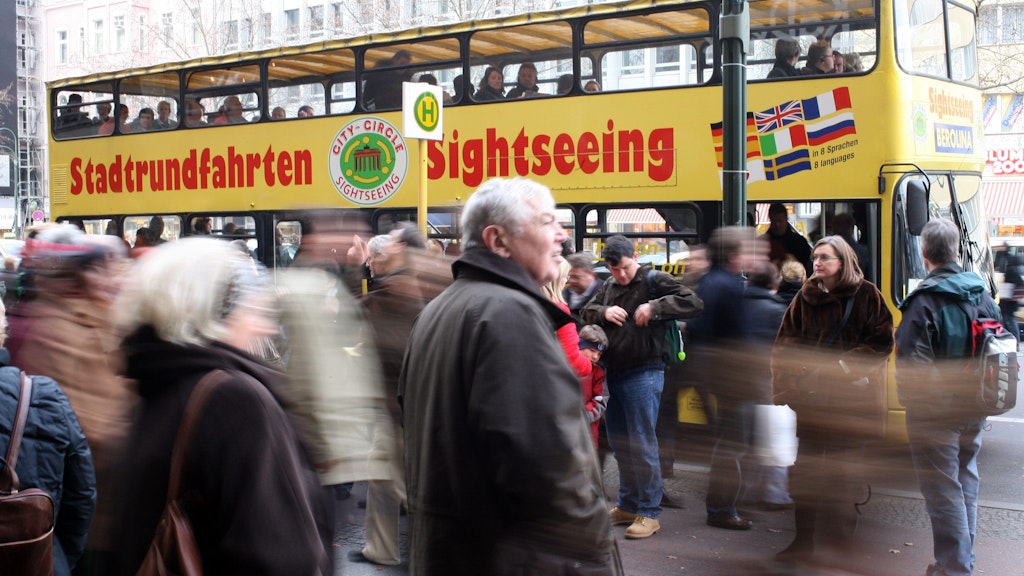 Die Touristenbusse zuckeln mit vielen Leuten durch die Straßen Berlins.