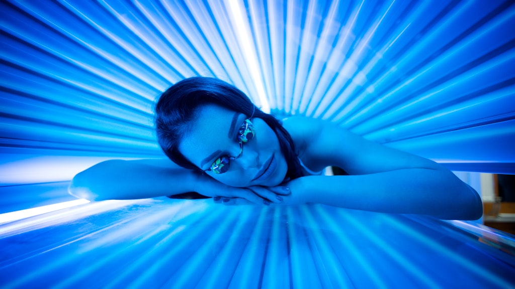 Eine Frau liegt im Solarium.