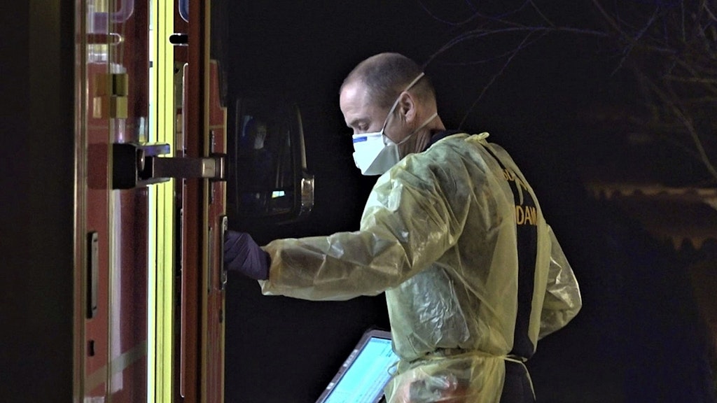 Ein Mitarbeiter des Rettunsgdienstes kommt mit Schutzkleidung aus dem Einsatzwagen (Archivbild).