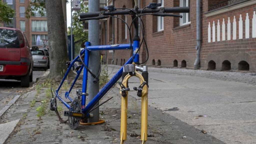 Ein ausgeschlachtetes Schrott-Fahrad steht angeschlossen an einem Laternenmast in Berlin-Prenzlauer Berg. (Symbolbild)