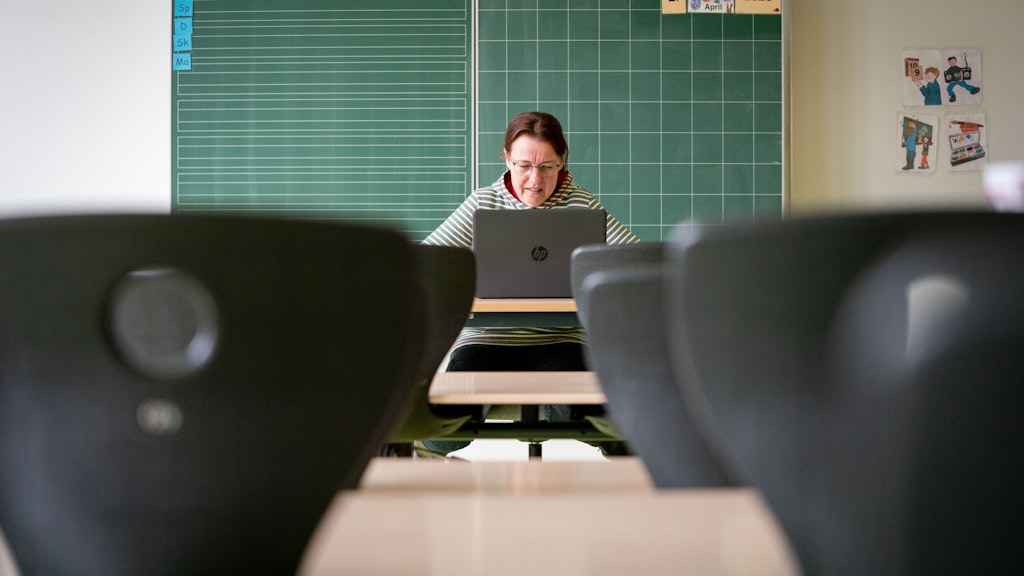Karin Bitter, Lehrerin an der Comenius Grundschule in Oranienburg, sitzt in ihrem leeren Klassenzimmer vor einem Laptop. Bald sollen die Schüler wieder zurückkommen.