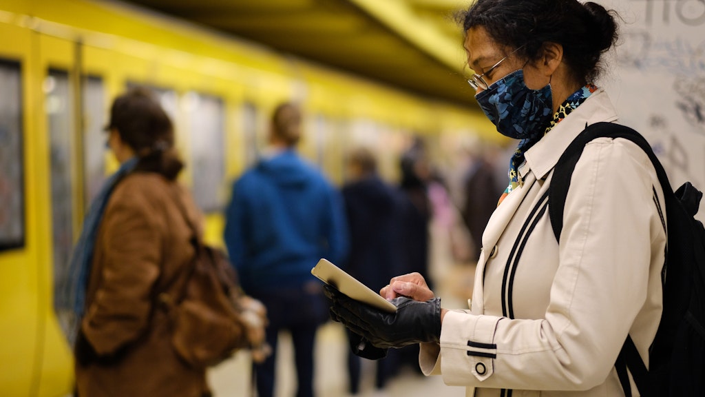 Frau mit Maske am U-Bahnhof.