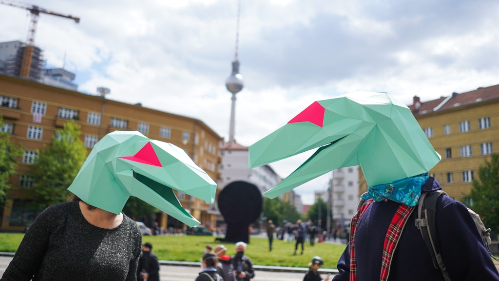 Kreativer Protest: Zwei als Echsen verkleidete Demonstranten auf dem Rosa-Luxemburg-Platz.