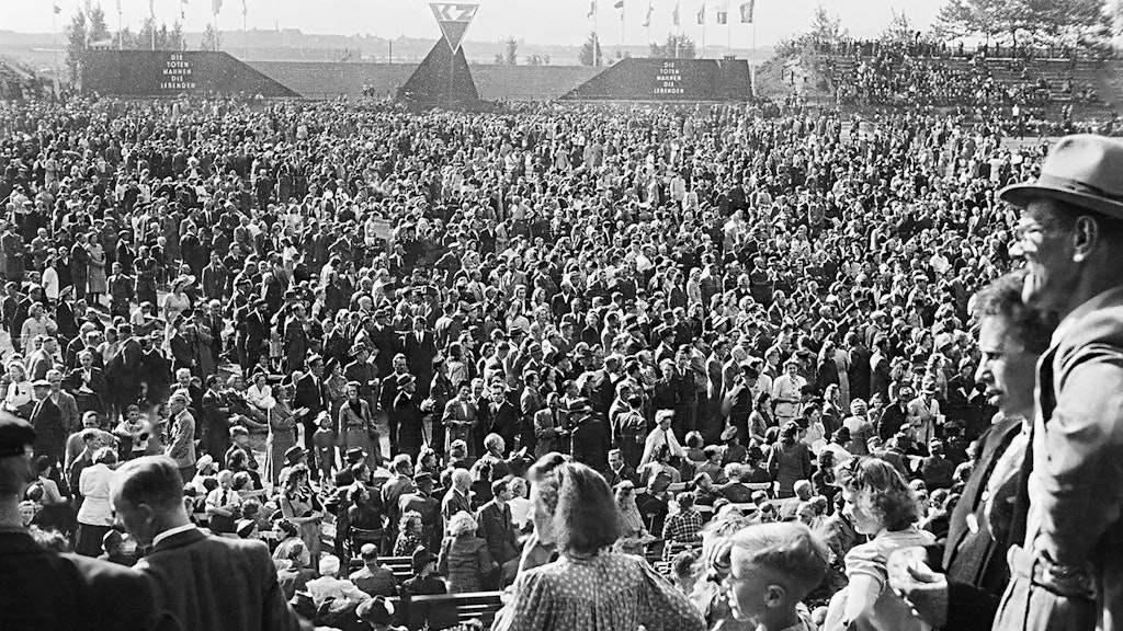 Gedächtnisfeier für die „Opfer des Faschismus“ im September 1945: Am „1. OdF-Tag“, dem 9. September 1945, fotografiert Abraham Pisarek, selbst Überlebender, die Versammlung im Rund der Werner-Seelenbinder-Kampfbahn in Berlin-Neukölln. Das Stadion ist seit dem 29. Juli 1945 nach dem im Jahr zuvor hingerichteten kommunistischen Sportler benannt.