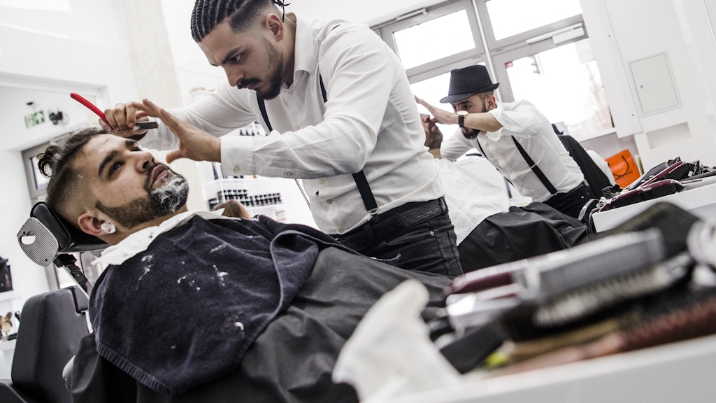 Trotz Wiedereröffnung nicht erlaubt: Barbier Onay Temel (Schöneberg) bearbeitet mit dem Rasiermesser den Bart eines Kunden. (Liebe Leser: Dieses Foto wurde vor dem Shutdown aufgenommen. Mittlerweile gilt auch in Onay Temels Salon die Maskenpflicht.)