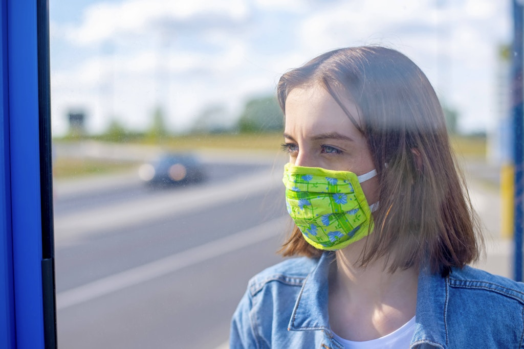 Warten auf den Bus. In öffentlichen Verkehrsmitteln muss eine Maske getragen werden.