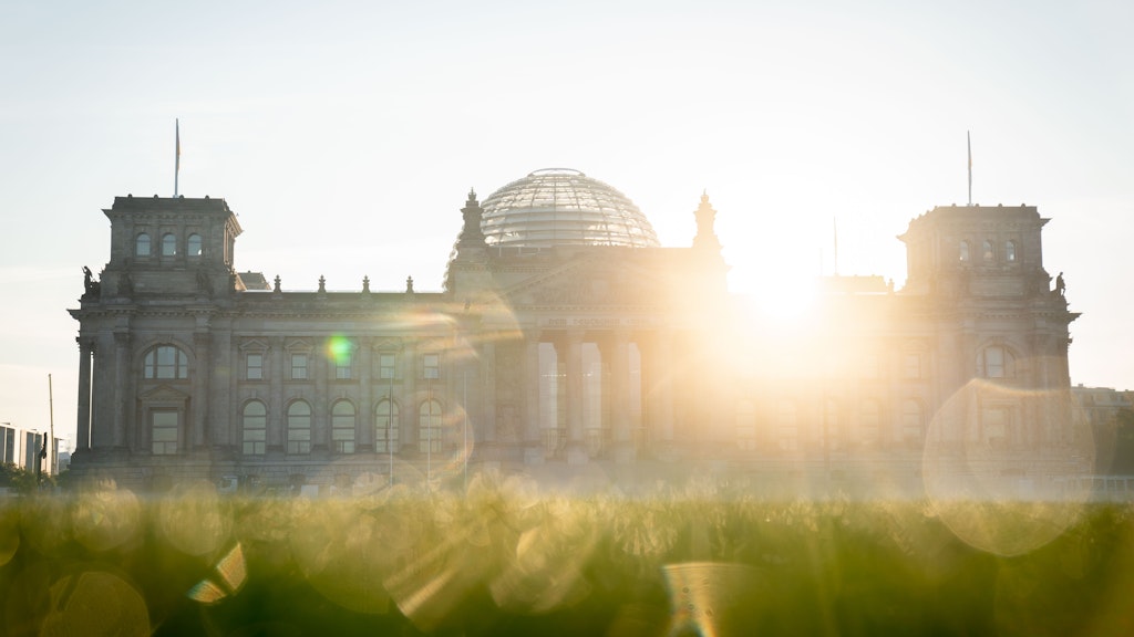 Die Sonne geht am Morgen hinter dem Reichstagsgebäude auf. Zum Wochenende wird es schön.
