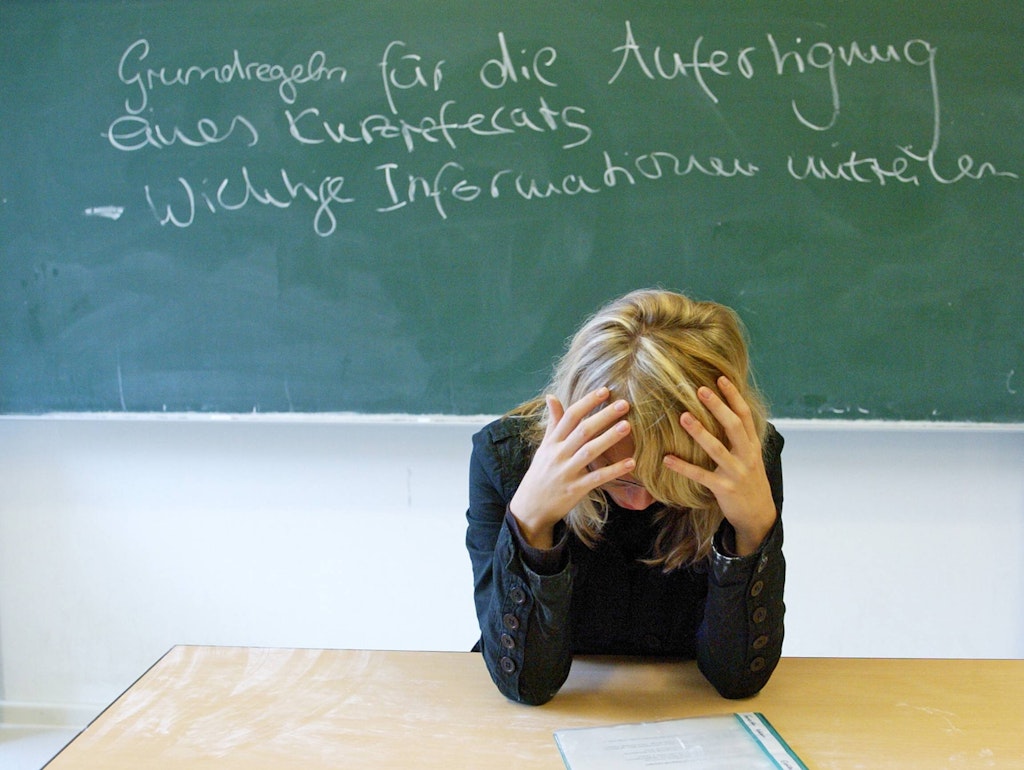 Zu hohe Erwartungen, zu wenig Wertschätzung: Verzweifelte Lehrerin in einem Klassenzimmer . 