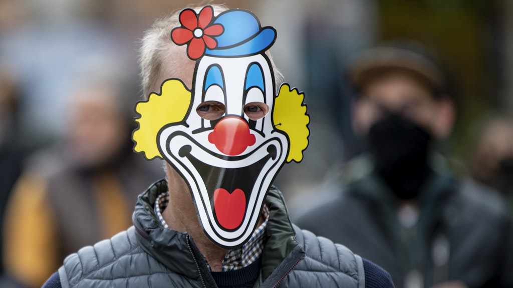 Ein Mann läuft mit einer Clownsmaske aus Papier durch die Berliner Innenstadt. Er ist Teilnehmer der „Wir müssen reden“-Demonstration, die sich gegen die Corona-Maßnahmen richtet. 