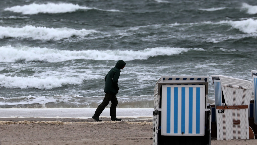 Warnemünde: Ein Spaziergänger ist an der aufgewühlten Ostsee unterwegs. 
