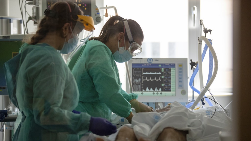 Mitarbeiterinnen eines Krankenhauses behandeln einen infizierten Patienten auf der Intensivstation.