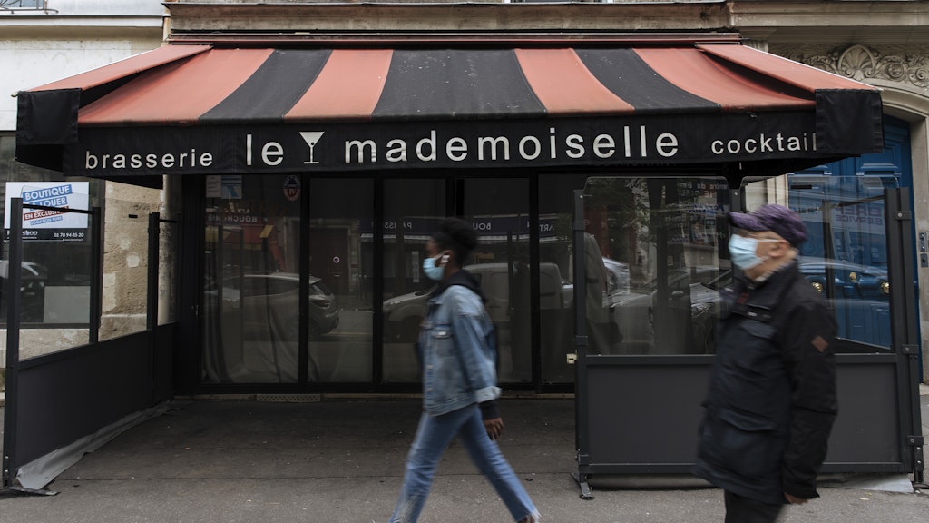 Paris: Passanten mit Mund-Nasen-Bedeckungen gehen an einer geschlossenen Bar vorbei. 
