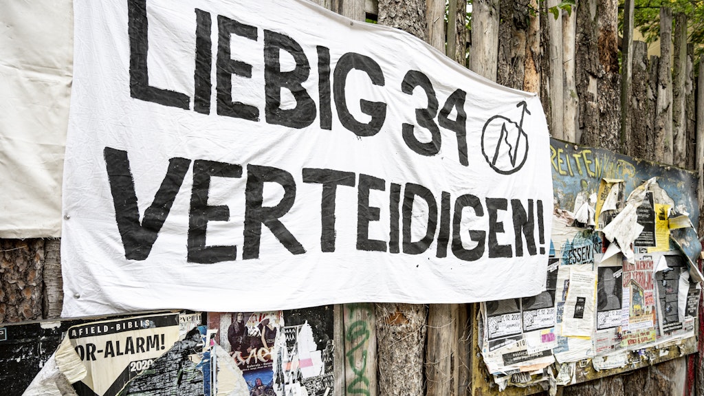 An einem Holzzaun in der Liebigstraße in Berlin-Friedrichshain hängt ein Banner mit der Aufschrift „Liebig 34 verteidigen“. Am 9. Oktober soll das Wohnprojekt „Liebig 34“ von der Polizei geräumt werden.