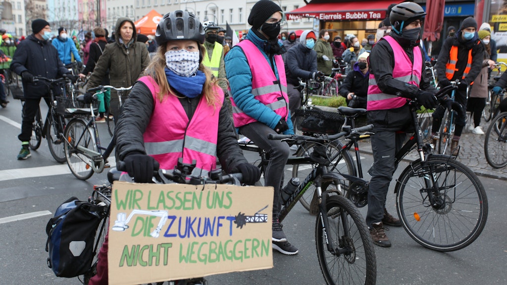 Auf dem Protestschild der Demonstrantin steht: „Wir lassen uns die Zukunft nicht wegbaggern.“