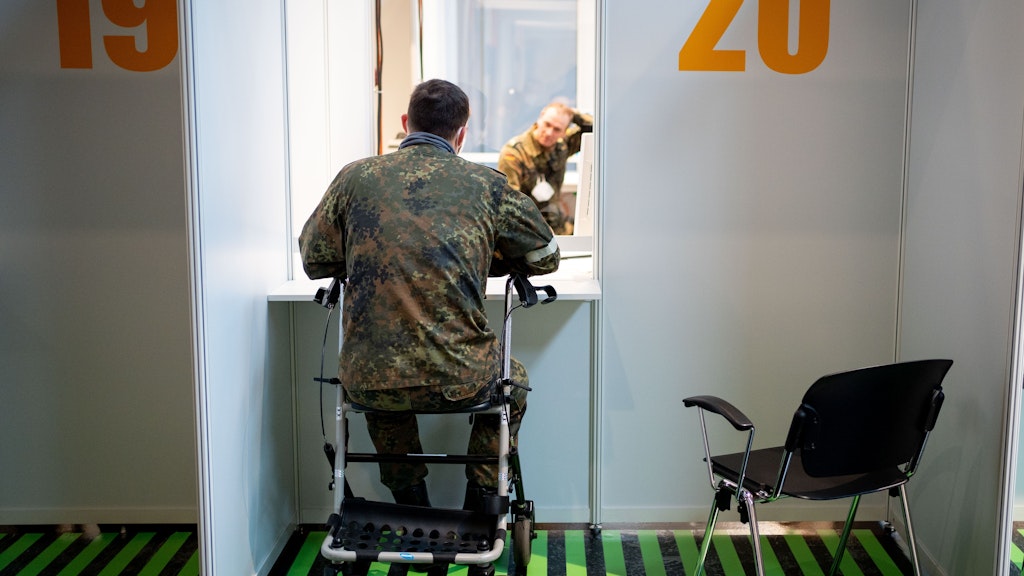 Ein Bundeswehrsoldat nimmt als Statist mit Rollator am Testlauf im Impfzentrum teil.