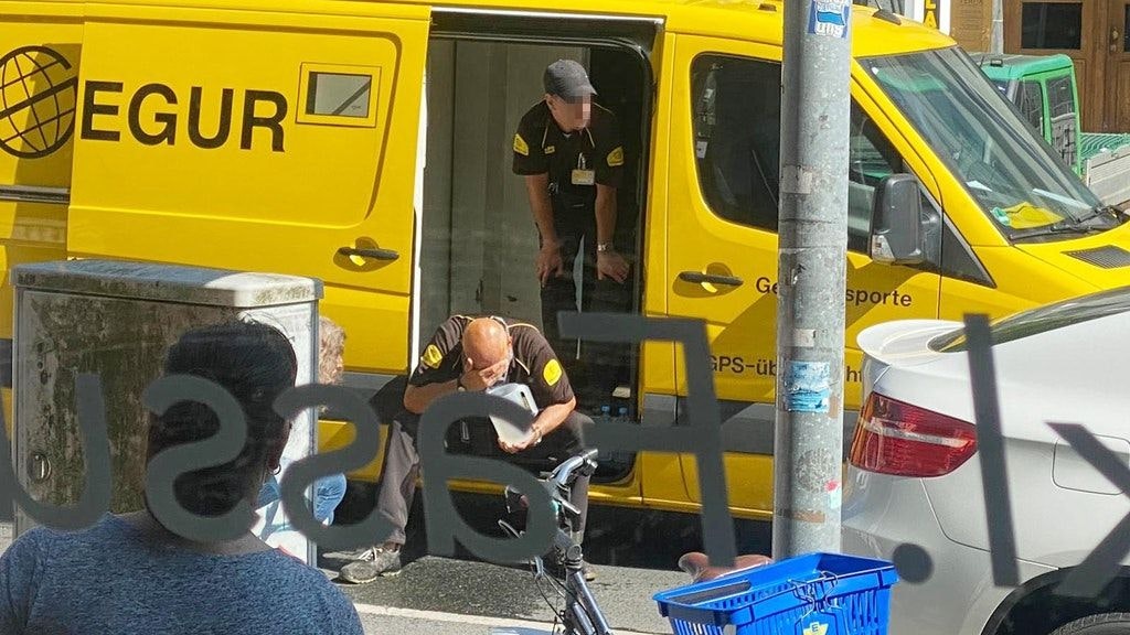 An armoured car guard rubs his eyes after being attacked with pepper spray during a robbery 16 June in Wilmersdorf.