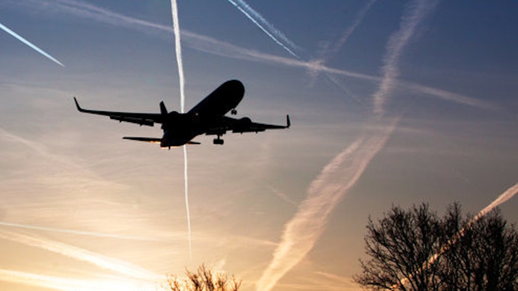 Ein Flugzeug landet bei aufgehender Sonne auf einem Flughafen.