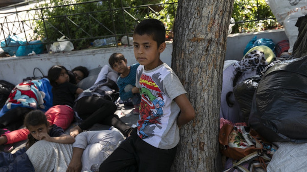 Afghanische Flüchtlinge liegen mit ihren Familien nach ihrer Ankunft aus dem Lager von Moria auf einem zentralen Platz.