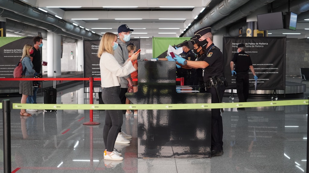 Polizisten überprüfen am 15.06.2020 die Ausweispapiere von deutschen Passagieren, die gerade auf dem Flughafen Palma de Mallorca angekommen sind. 