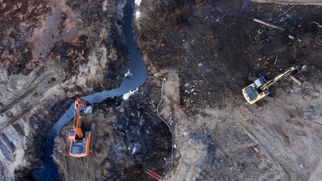 In Norilsk versuchen Einsatzkräfte, mit Baggern die Ausbreitung des Ölteppichs zu verhindern. 