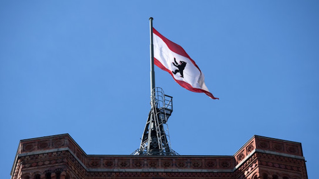 Die rot-weiße Berliner Flagge mit dem Berliner Bären auf dem Roten Rathaus in Berlin.