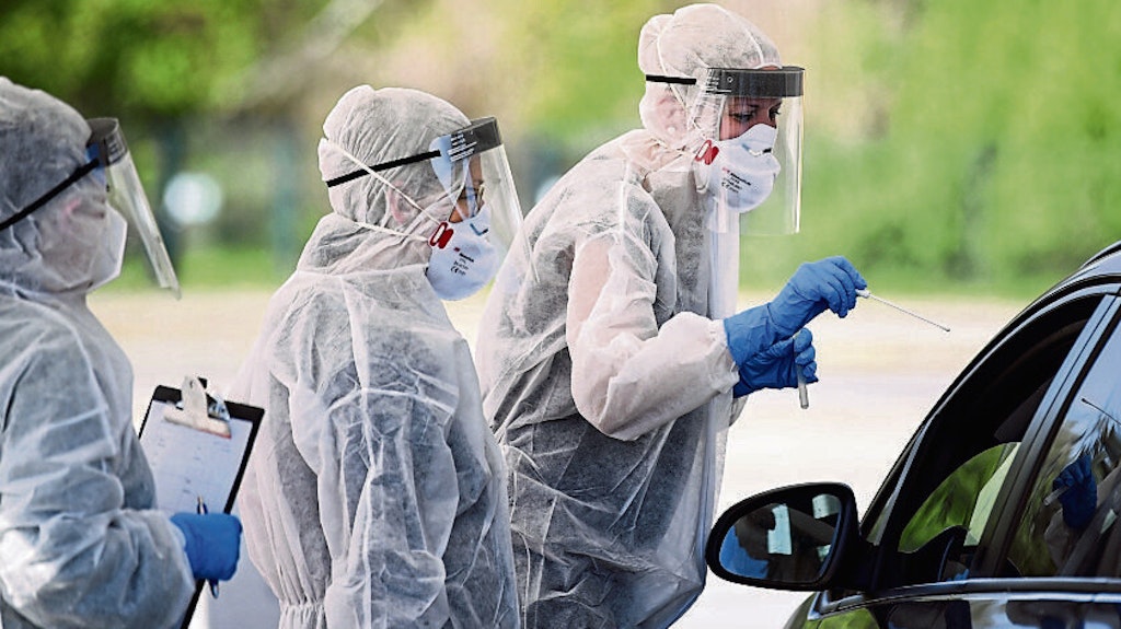 Mitarbeiter vom Gesundheitsamt in Mitte nehmen Proben durch ein Autofenster auf dem zentralen Festplatz in der ambulanten Corona-Test- Einrichtung. 
