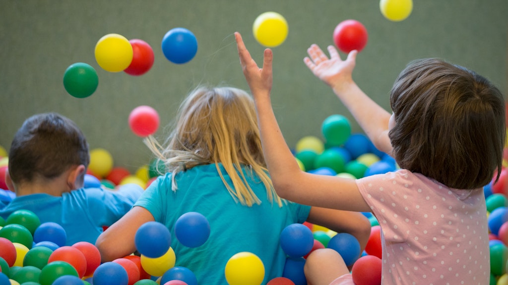 Kinder spielen in einem Bällebad.