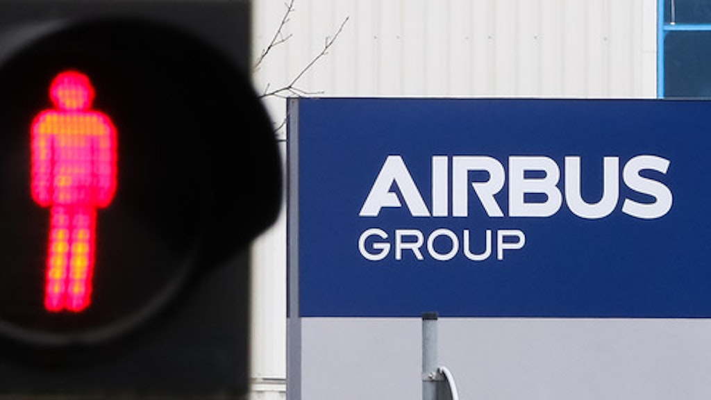 Eine Ampelmännchen steht vor dem Airbus-Gebäude auf rot.