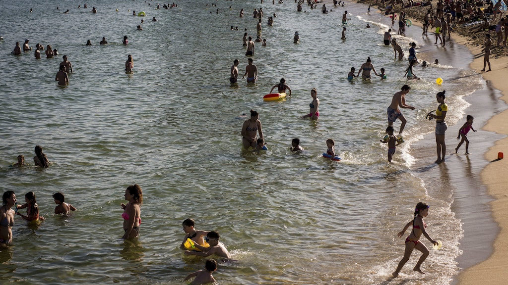 Zahlreiche Menschen baden im Meer in und genießen den Strand von Nova Icaria in Barcelona. +++ dpa-Bildfunk +++