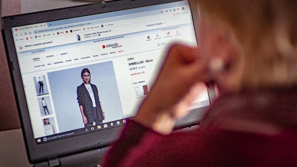 Berlin: Frau mit Notebook surft im Internet bei Zalando.