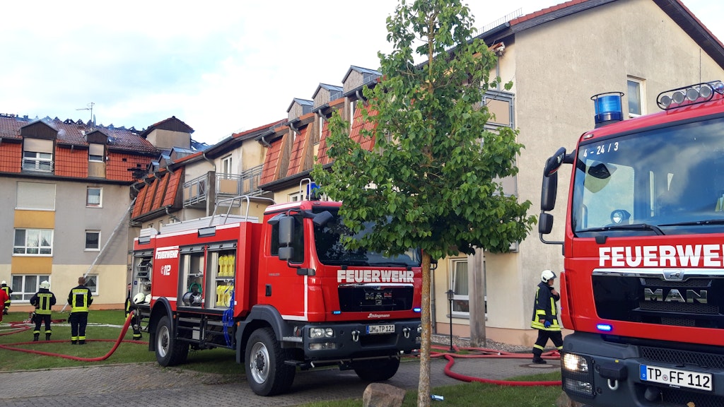 Feuerwehrfahrzeuge stehen vor dem Gebäude eines Pflegeheims. Nach einem Brand in einem Pflegeheim in Templin ist ein Mensch tot geborgen worden.