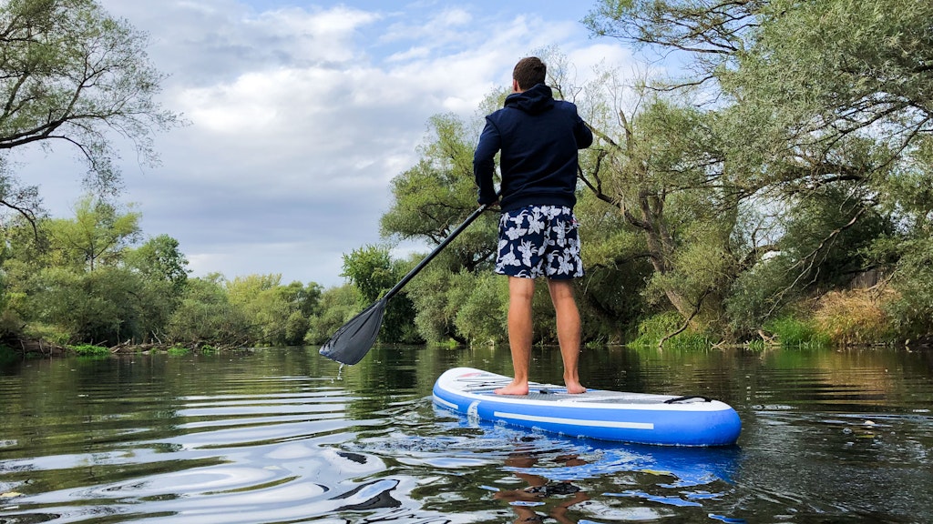 Immer schön in die Natur, immer schön vom Ufer wegbleiben: Stand-up-Paddler in der Natur.