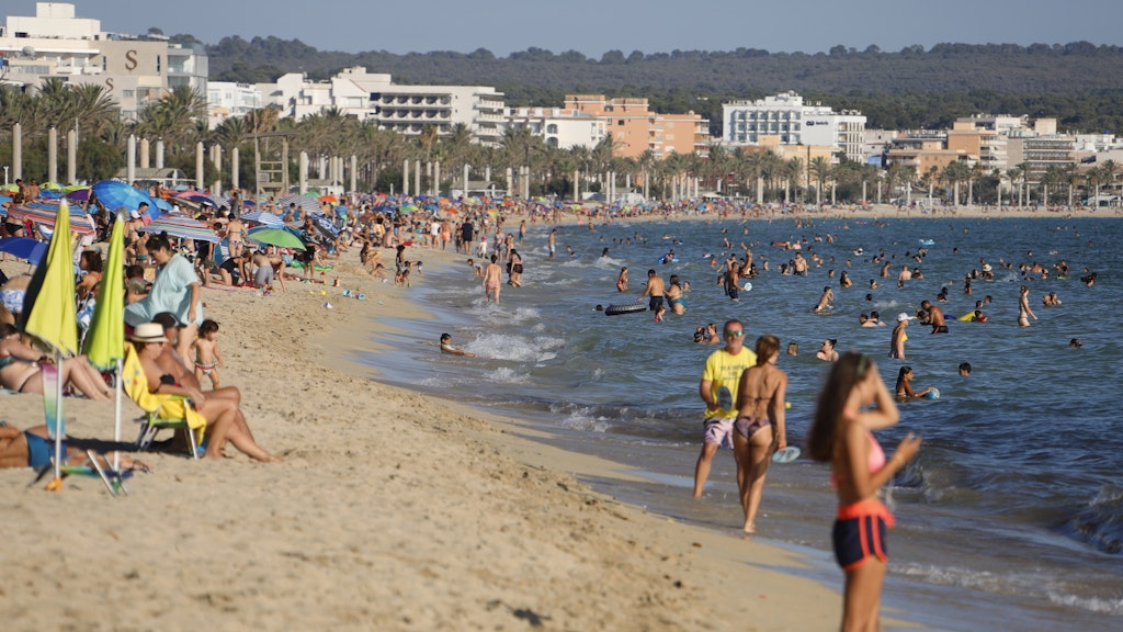 Menschen genießen die Sonne am Strand von El Arenal. 