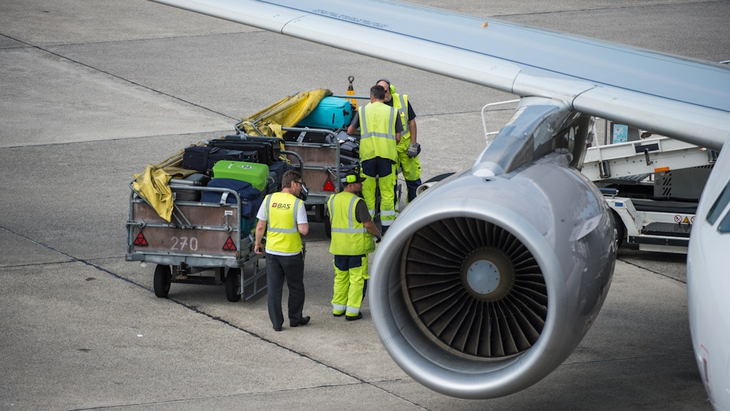 Mitarbeiter des Bodenpersonals am Flughafen entladen eine Lufthansamaschine. Reiserückkehrer sollen sich an den Berliner Flughäfen für einen Coronaschnelltest bereithalten.