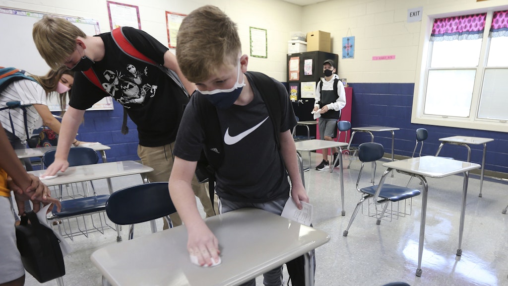 Zach Lee, ein Achtklässler an der Guntown Middle School, desinfiziert einen Schreibtisch.