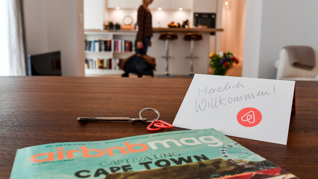 Ein Schlüssel mit einem Airbnb-Anhäger, ein Airbnbmag-Magazin und eine Herzlich-Willkommen-Karte liegen in der Wohnung eines Airbnb-Gastgebers (Symbolbild). 