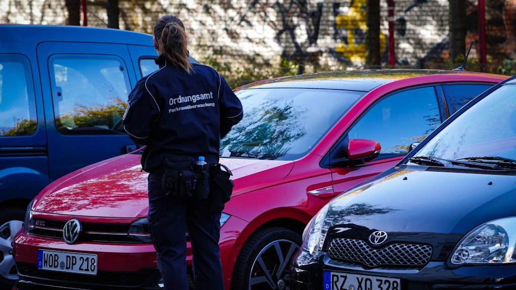 Eine Ordnungsamtsmitarbeiterin prüft, ob in den Autos Parkscheine liegen. 
