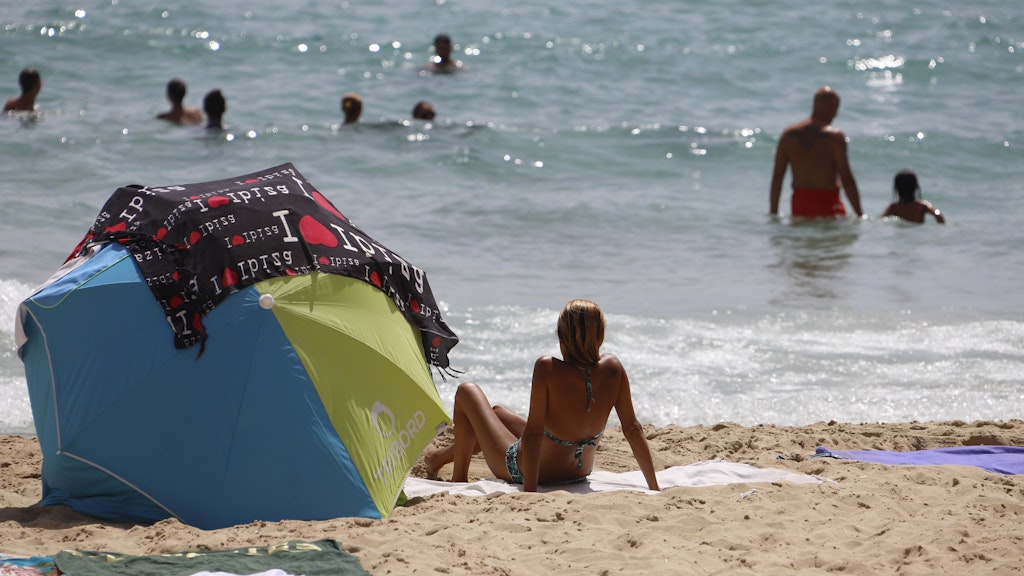 Eine Frau sonnt sich am Strand von Cala Major.