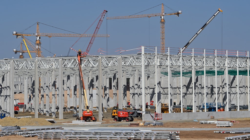 Kräne, Baumaschinen und erste Betonpfeiler für die künftige Tesla-Gigafactory auf dem Baugelände in Grünheide bei Berlin.