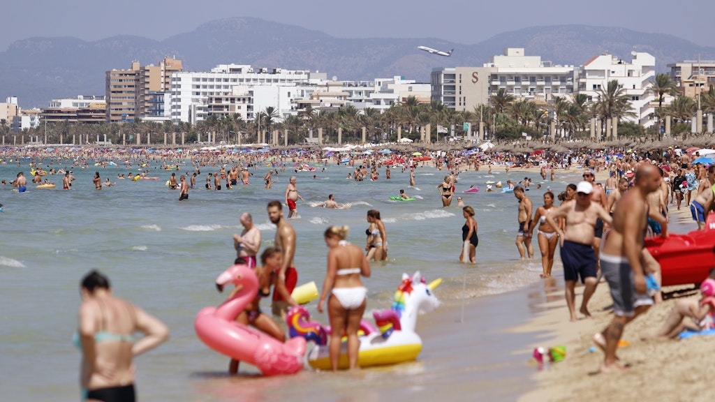 Touristen am Strand von El Arenal auf Mallorca. 