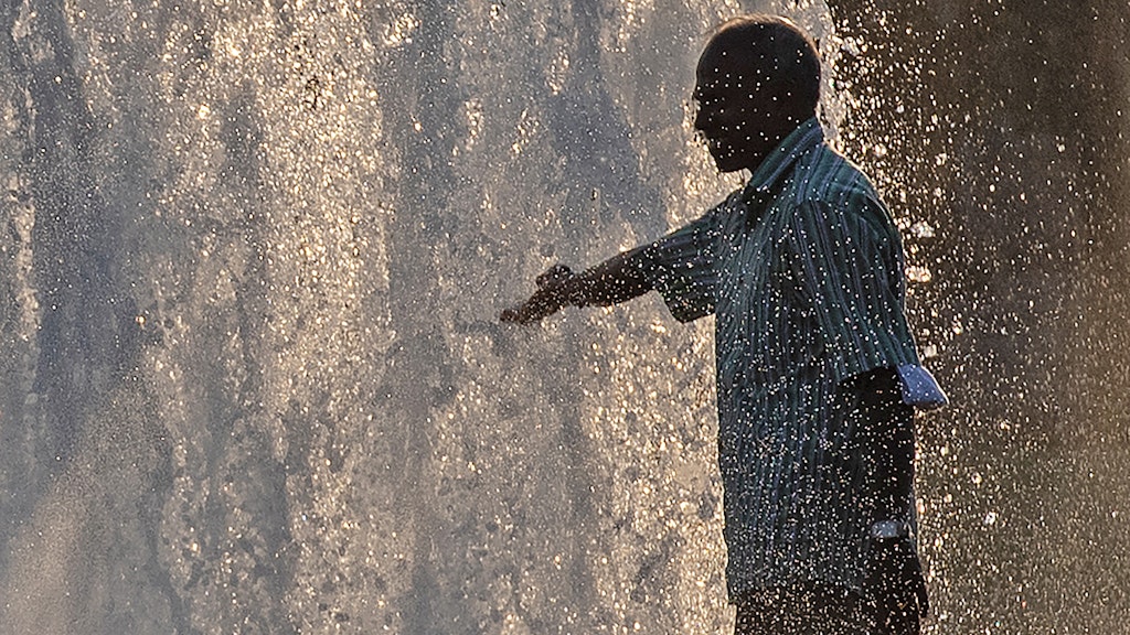 Ein Mann erfrischt sich abends am Wasser des Springbrunnens im Lustgarten. 