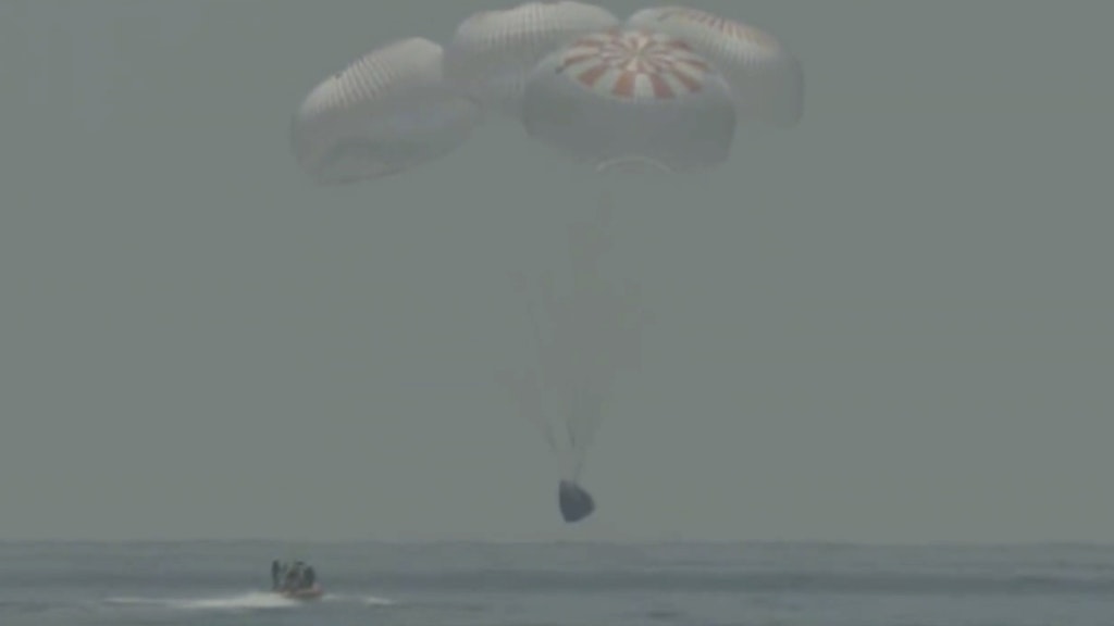 Fallschirme bremsen die SpaceX-Kapsel auf dem Weg zur Wasseroberfläche.