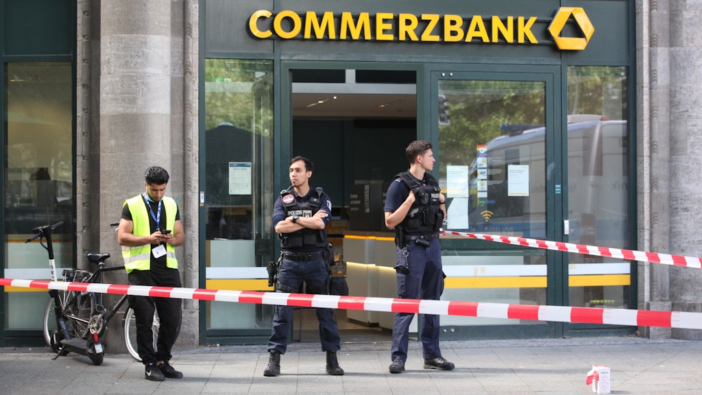 Polizisten bewachen den Eingang einer Commerzbank-Filiale. Der mutmaßliche Bankräuber war mit einem Messer bewaffnet. <br>