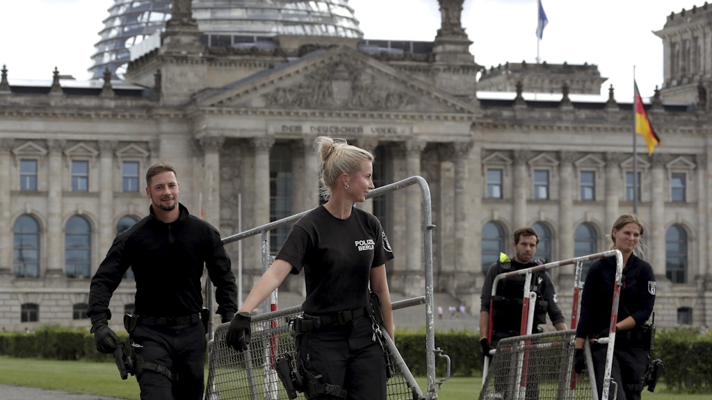 Polizisten entfernen die Absperrgitter am Reichstag.