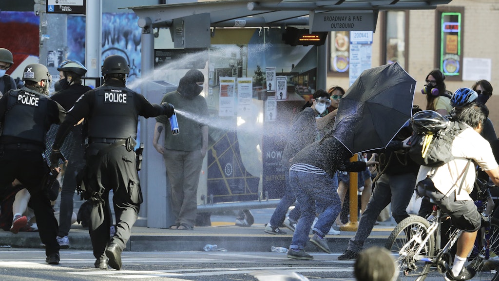 Polizisten sprühen in der Nähe des Seattle Central Community College Pfefferspray auf Demonstranten.