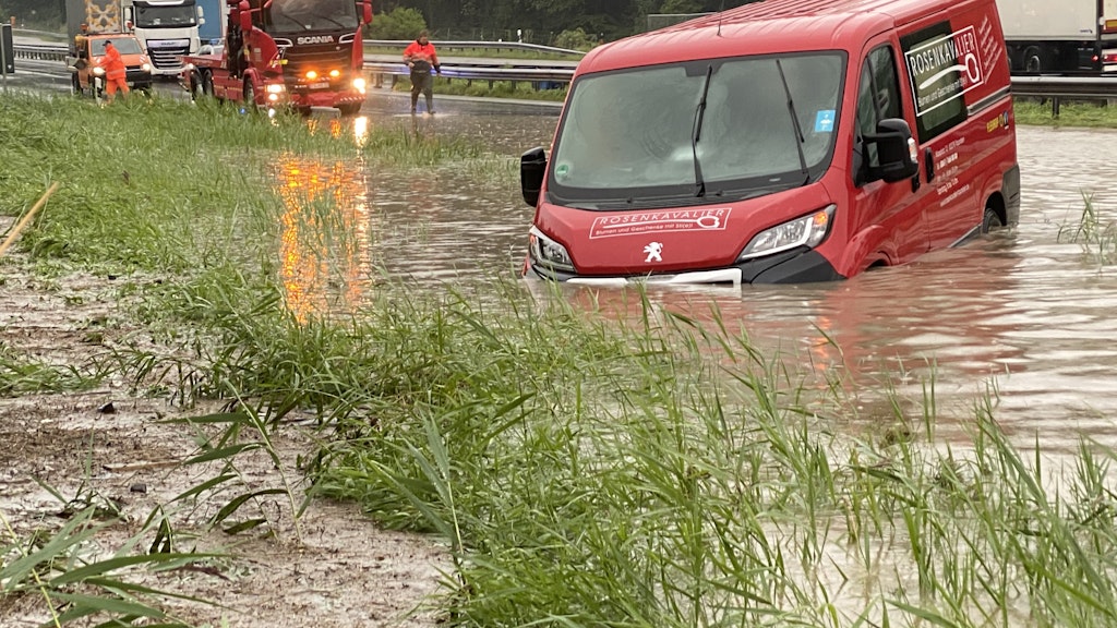 Achenmühle: Ein Transporterfahrer hängt auf der A8 mit seinem Fahrzeug in den Fluten.