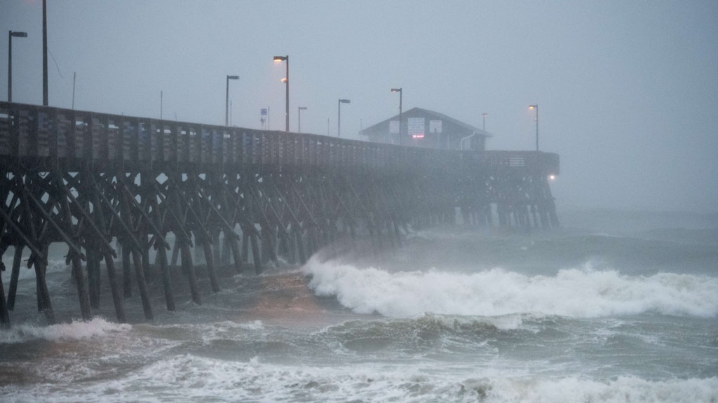 Wellen schlagen gegen den Pier von Garden City in South Carolina. 