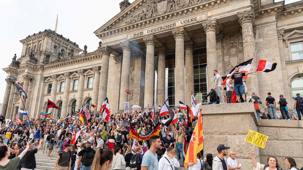 Teilnehmer einer Kundgebung gegen die Corona-Maßnahmen stehen vor dem Reichstag.